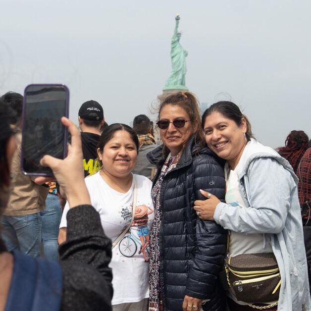Ladies posing in front of the Statue of Liberty