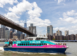 the Brooklyn bridge and Manhattan skyline including the one world trade center in the background of a freedom liberty cruise boat