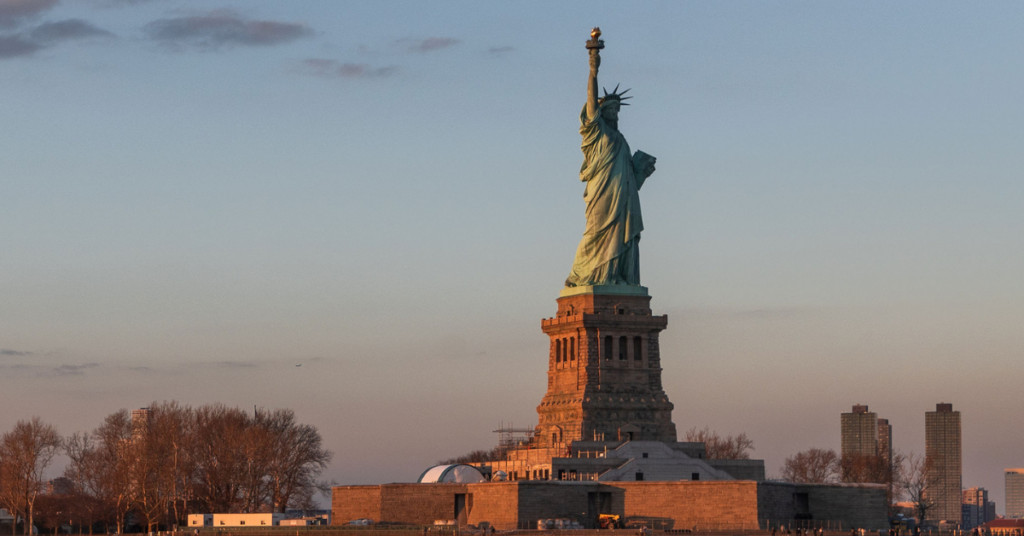 statue of liberty at sunset as seen from the hudson river