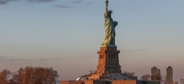 statue of liberty at sunset as seen from the hudson river