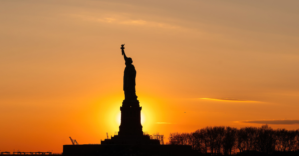 Sun setting being the Statue of Liberty