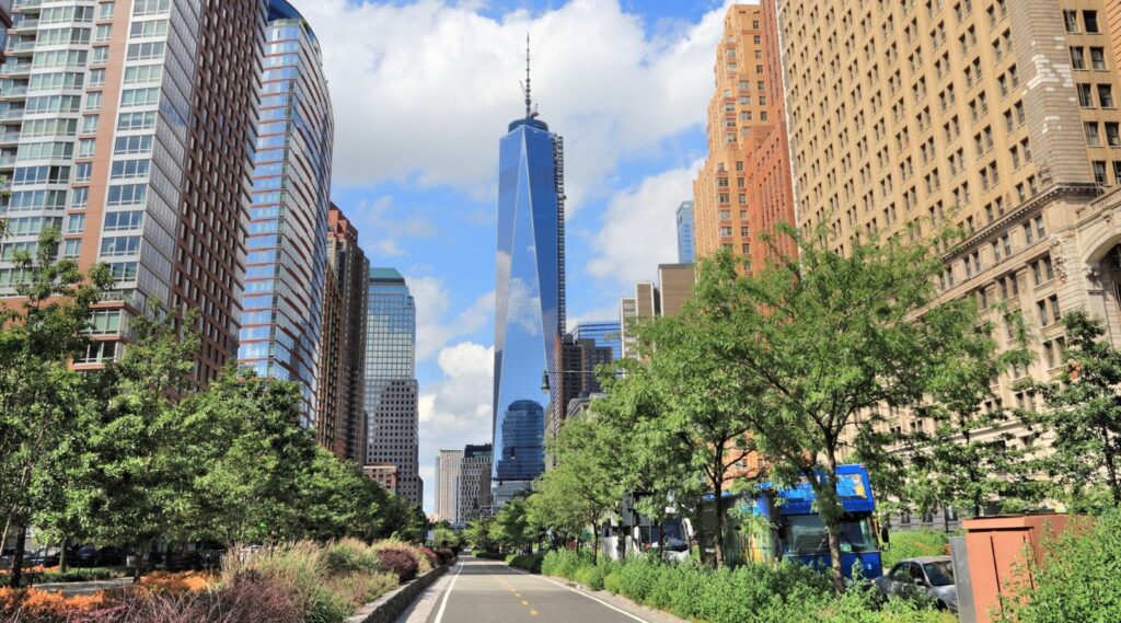 a bike path with trees and buildings off to the side on the Hudson River Greenway